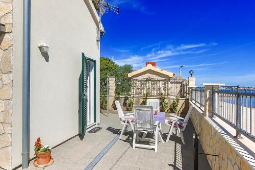 a patio with chairs and a table on a balcony at Riva in Krapanj