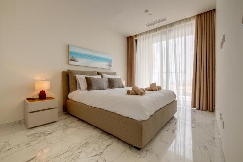 a bedroom with a large bed and a large window at Mercury Tower Apartments in St Julian's