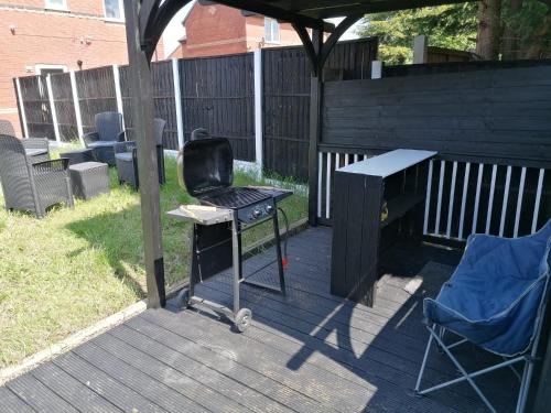 a grill and a table and a chair on a deck at Affluent Living Property perfect for contractors and individuals in Wigan