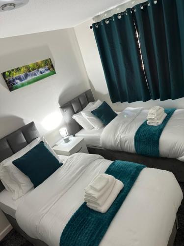 two beds in a bedroom with blue and white at Affluent Living Property perfect for contractors and individuals in Wigan