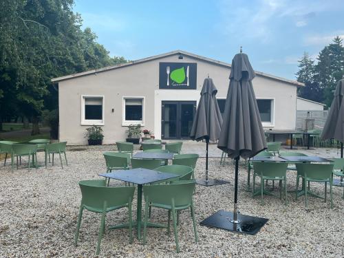 a group of tables and umbrellas in front of a building at Pfarrhaus Tollensesee in Penzlin