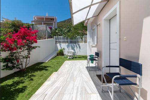 a balcony with chairs and flowers on a building at Amazing villa with a magic view to the Aegean in Dhaskalión