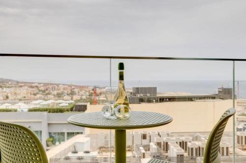 a table with a bottle of wine on top of a balcony at Mercury Tower Apartments in St Julian's