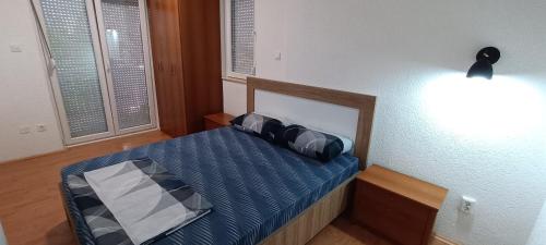 a small bedroom with a bed with a blue comforter at Apartment Pe-Pa Ohrid in Ohrid