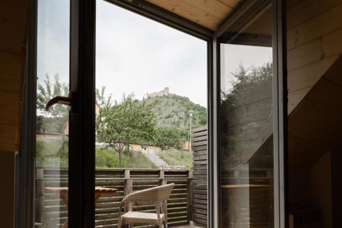 a window with a chair and a view of a hill at PavLove Apartment in Pavlov