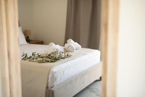 a bedroom with a bed with towels and flowers on it at Three Charites Resort in Gialova