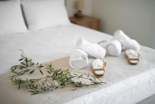 a bed with two shoes and a bunch of flowers at Three Charites Resort in Gialova