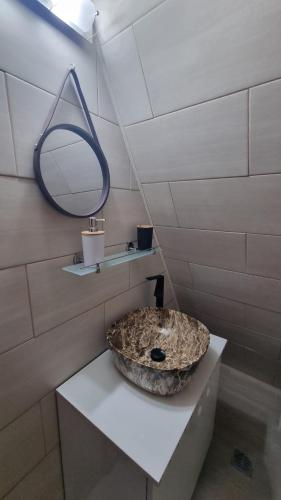 a bathroom with a stone sink and a mirror at Cazare la mare Cabana Alina in Papuci