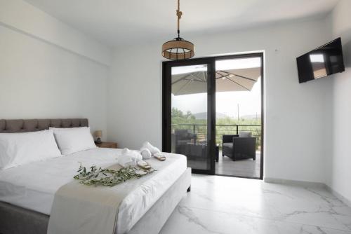 a bedroom with a white bed with flowers on it at Three Charites Resort in Gialova