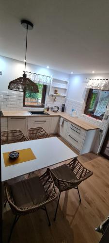 a kitchen with a table and two chairs and a counter at Malinowa Chata- Królowy Most in Królowy Most
