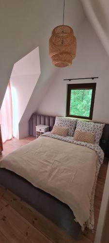 a bedroom with a large bed and a window at Malinowa Chata- Królowy Most in Królowy Most