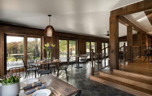 a dining room with wooden walls and tables and windows at Hemlock Neversink in Neversink