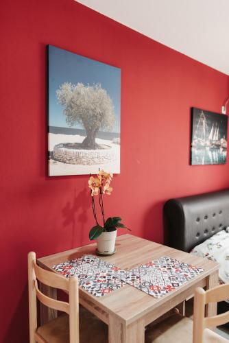 a table in a room with a red wall at Guesthouse Lole in Bar