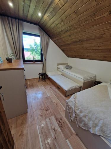 a large room with two beds and a window at Chata pod Cigerníkom in Matiašovce