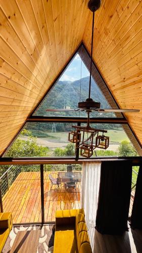 a living room with a large window in a cabin at Aleksandria house in Chinkadzeebi
