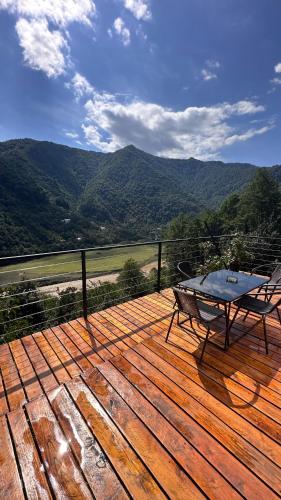 a wooden deck with a table and a bench on it at Aleksandria house in Chinkadzeebi
