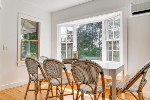 a dining room with a table and chairs and windows at Walk to 2 Beaches Pocasset Home with Kayaks and Bikes in Pocasset