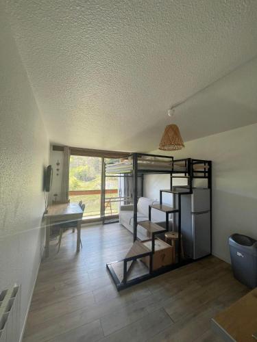 une chambre avec un lit superposé et un bureau dans une chambre dans l'établissement Appartement au pied des pistes, au Corbier