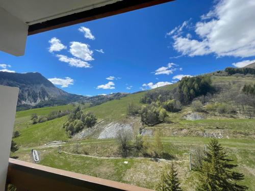 a view from a window of a mountain view at Appartement au pied des pistes in Le Corbier