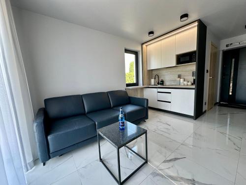 a living room with a blue couch and a table at Cobalt Apartments in Mikołajki