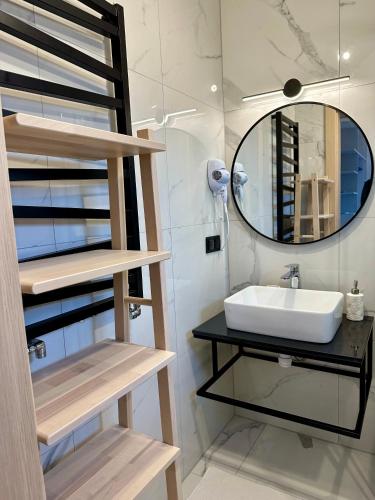 a bathroom with a sink and a mirror at Cobalt Apartments in Mikołajki