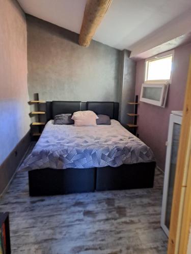 une chambre avec un grand lit dans une pièce dans l'établissement Maison de village - La Couronne, à Martigues