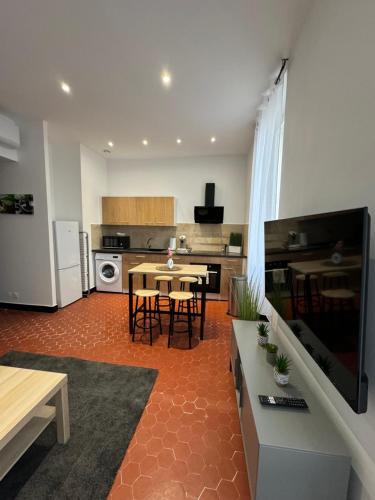 une cuisine avec une table et des chaises dans une pièce dans l'établissement Sublime appartement à l'Estaque Marseille, à Marseille