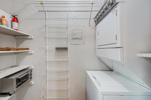 a kitchen with a white refrigerator and a white shelf at Convenient Bryan Townhome with Patio Less Than 3 Mi to AandM! in Bryan