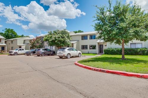 a house with cars parked in a parking lot at Convenient Bryan Townhome with Patio Less Than 3 Mi to AandM! in Bryan