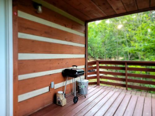 a grill on the side of a wooden porch at Romantic, Private Cabin in Smokies Hot Tub Firepit in Sevierville
