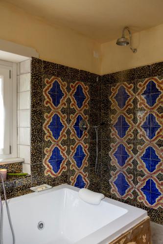 a bathroom with blue tiles on the wall and a tub at Villa De Cillis Carafa in Torre del Greco