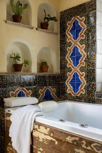 a bathroom with a tub with blue and gold tiles at Villa De Cillis Carafa in Torre del Greco