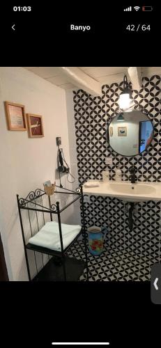 a bathroom with a sink and a tv on a wall at Maison Arzu & Mebrure in Gokceada Town