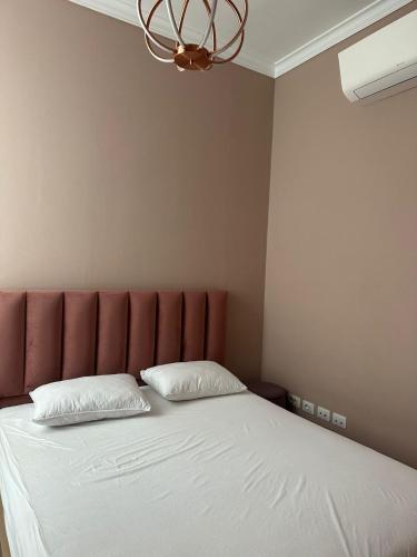 a bed with a red headboard and two white pillows at Seanest Greencoast in Himare