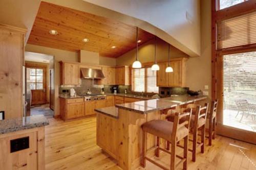 a large kitchen with wooden cabinets and a large island at Gold Rush Trail 12560 by East West Hospitality in Truckee