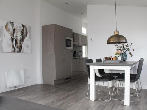 a dining room with a white table and chairs at Holiday Home in Limburg with Outdoor Fireplace in Bemelen