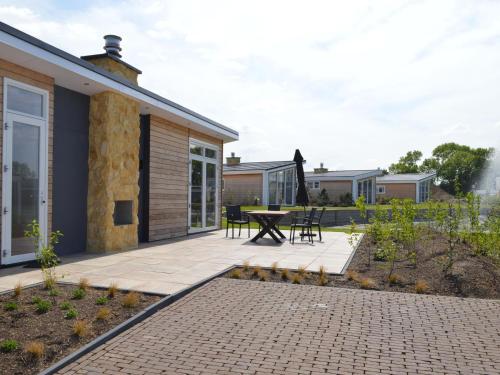 a patio with a table and chairs next to a house at Holiday Home in Limburg with Outdoor Fireplace in Bemelen