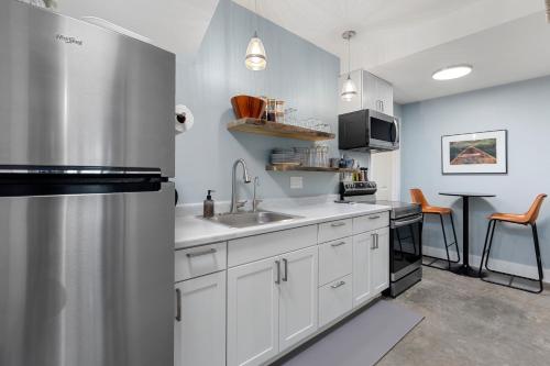 a kitchen with white cabinets and a sink at Hot Tub Family Friendly Garden City Getaway in Missoula