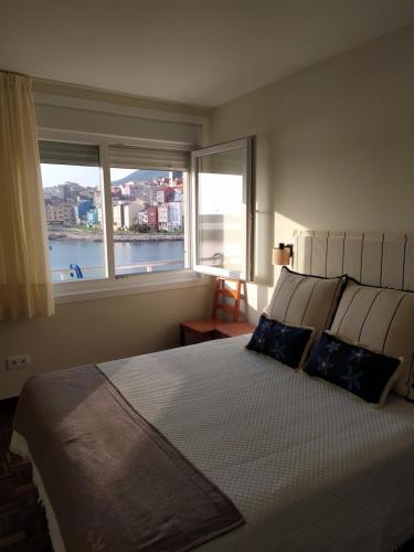 a bedroom with a large bed with two windows at Vacacional muelle alto A Guarda in A Guarda