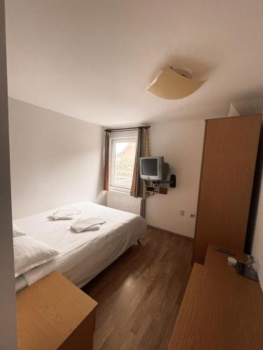 a small bedroom with a bed and a window at Pensiunea Hyperion Cormaia in Sîngeorz-Băi