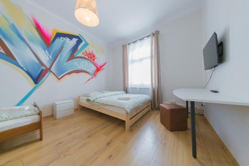 a bedroom with a bed with graffiti on the wall at Hostel Graffiti in Kraków