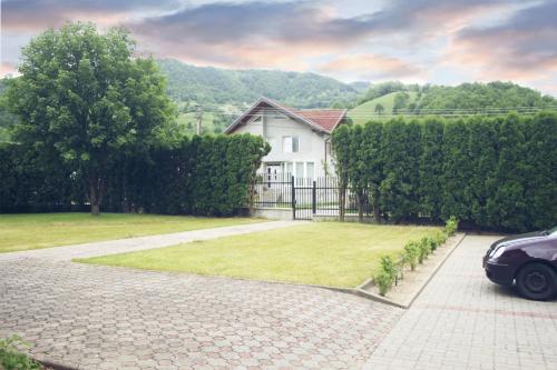 a car parked in front of a house at Pensiunea Hyperion Cormaia in Sîngeorz-Băi