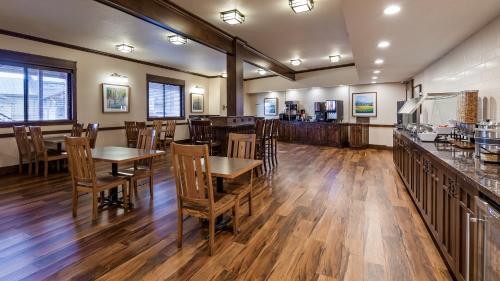 a restaurant with wooden tables and chairs and a bar at Best Western Plus High Country Inn in Ogden