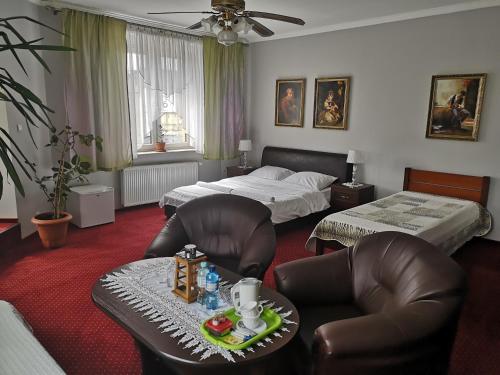 a bedroom with two beds and a table and chairs at Pokoje Goscinne in Orzesze