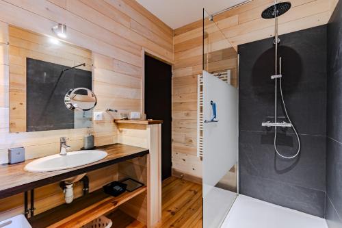 une salle de bain avec un lavabo et une douche dans l'établissement villa bois typique du bassin avec piscine chauffée au bord du lac, La Gde Escoure, à Lacanau