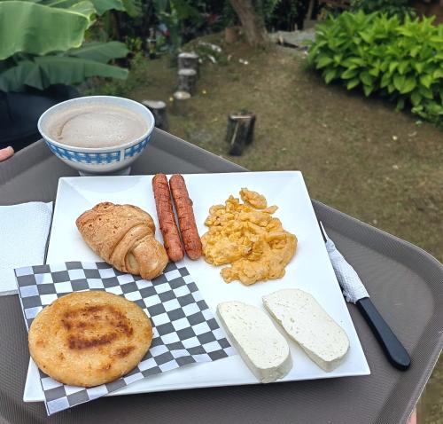 a plate of food with sausage and biscuits on a table at Cabaña trébol del campo in Ebéjico