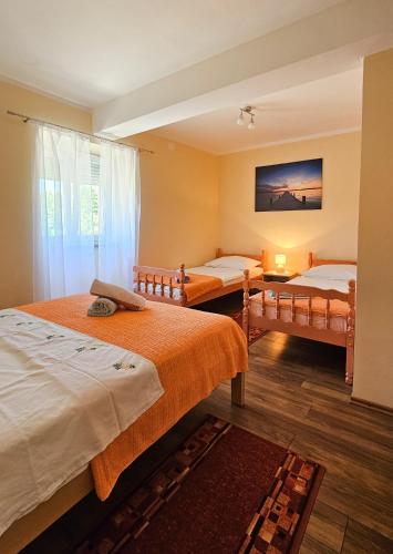 a room with two beds and a window at Apartman Petra in Vrh