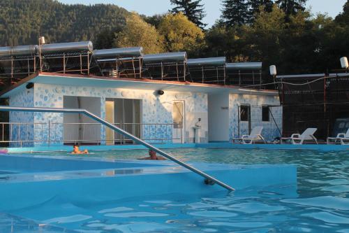 a house in the water with a pool at Pensiunea Hyperion Cormaia in Sîngeorz-Băi