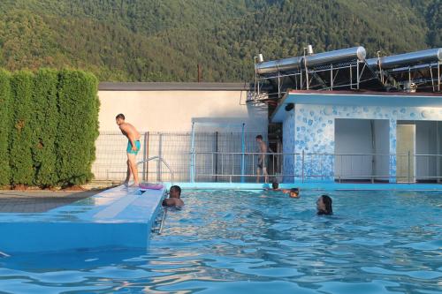 a man standing on a surfboard in a swimming pool at Pensiunea Hyperion Cormaia in Sîngeorz-Băi