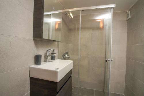 a bathroom with a sink and a shower at Work of Art apartment in Nea Michaniona in Néa Michanióna